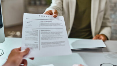 Close-up of job applicant giving his resume during job interview in the office.